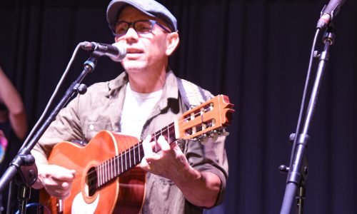 Primer plano de Orlis Pineda cantando y tocando su guitarra